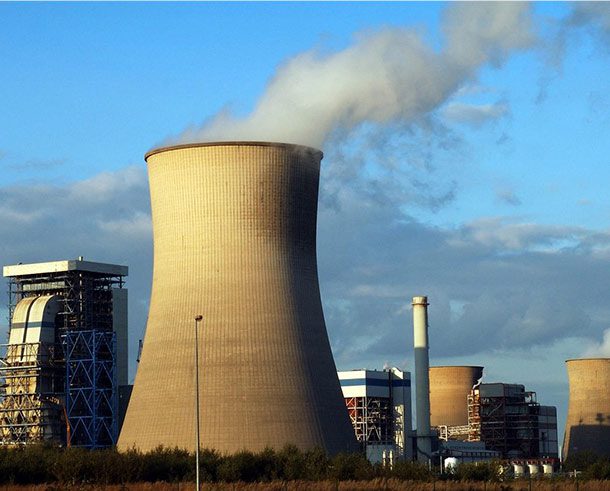 A large industrial building with smoke coming out of the top.