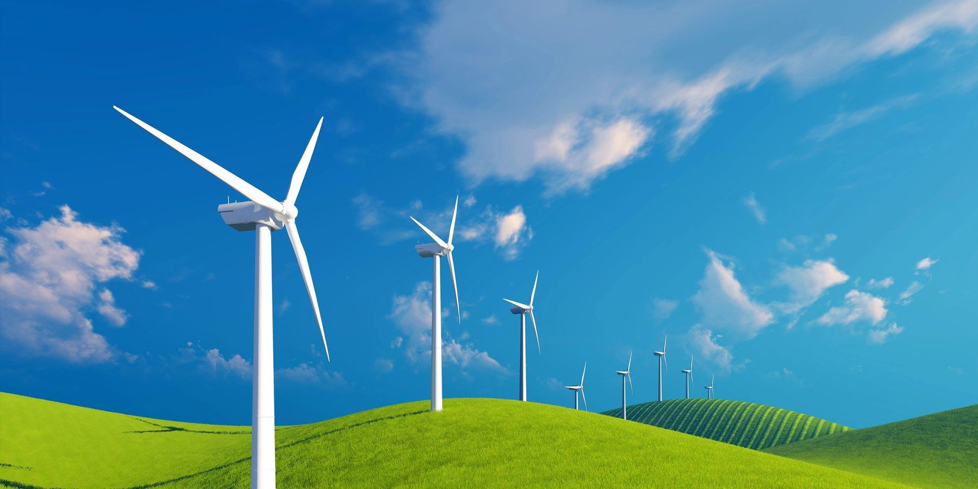 A group of wind turbines on top of a green hill.