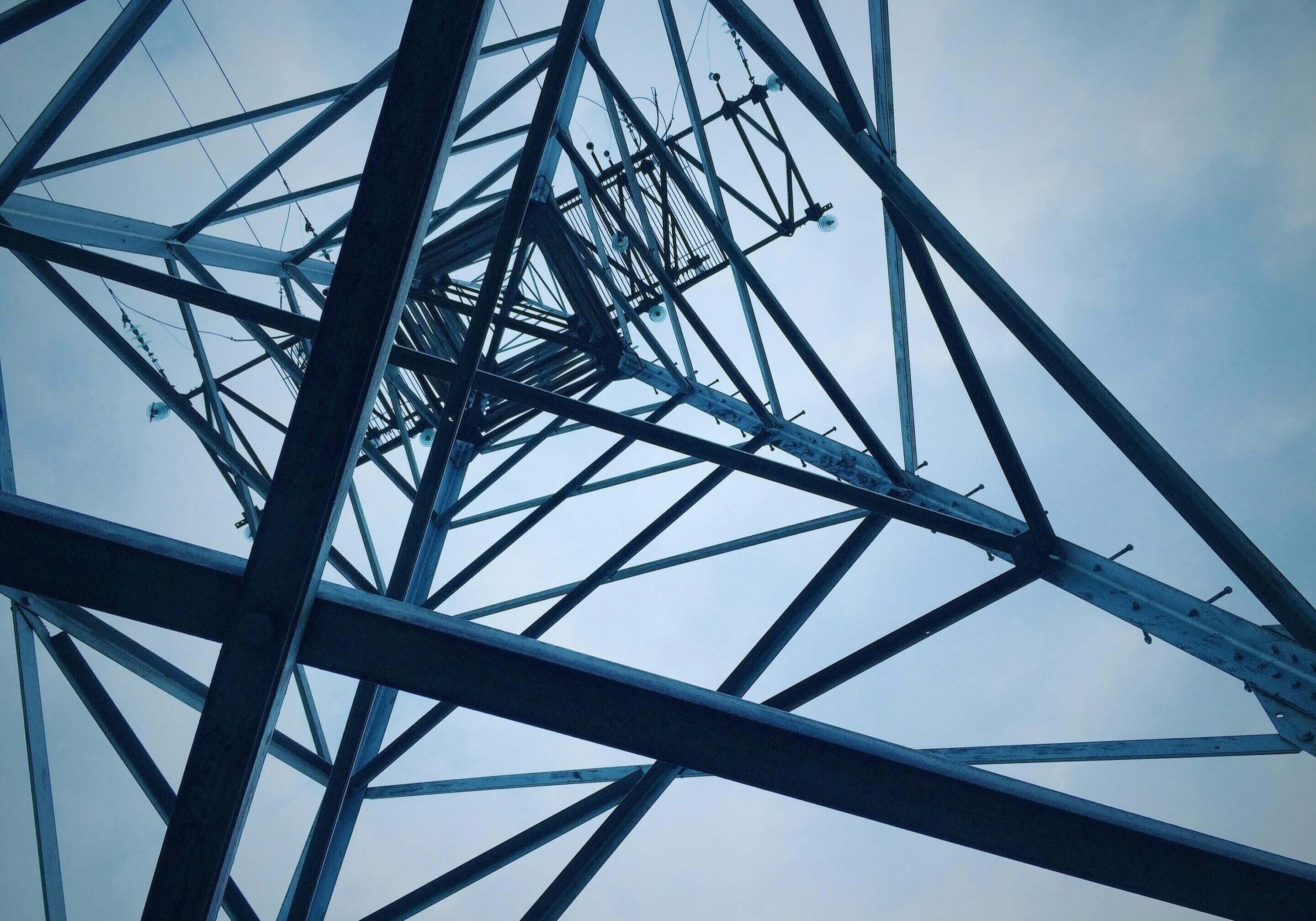 A close up of an electrical tower with wires